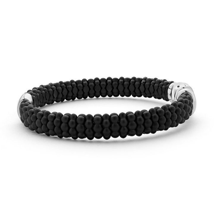 A side-view of a sterling silver beaded bracelet in the middle of a white background, featuring Matte black ceramic caviar beading and a gold single station