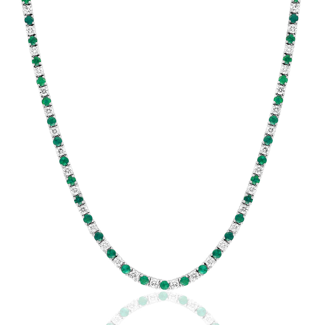 A close-up of a white-gold Emerald & Diamond Tennis Necklace against a white background. The necklace features 66 emerald round diamonds and 65 round diamonds.