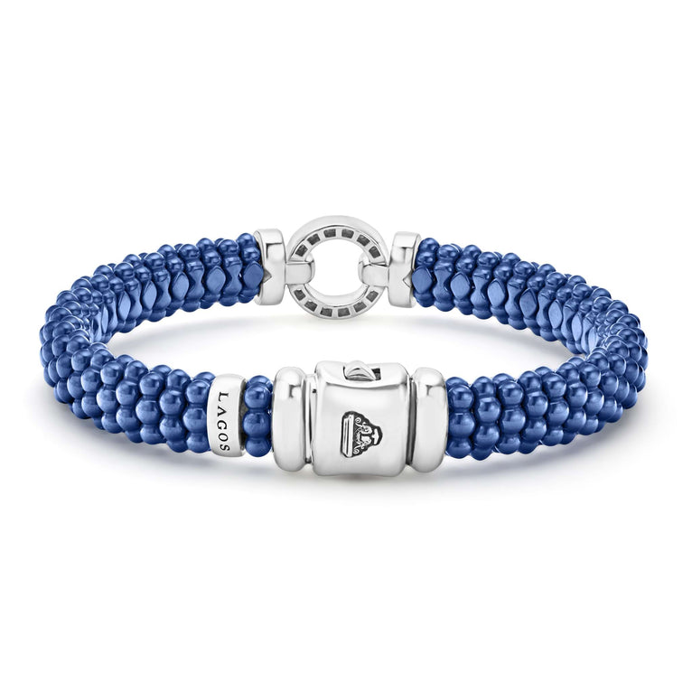 A sterling silver bracelet in the middle of a white background highlighting the clasp features a diamond circle motif and ultramarine ceramic caviar beading.