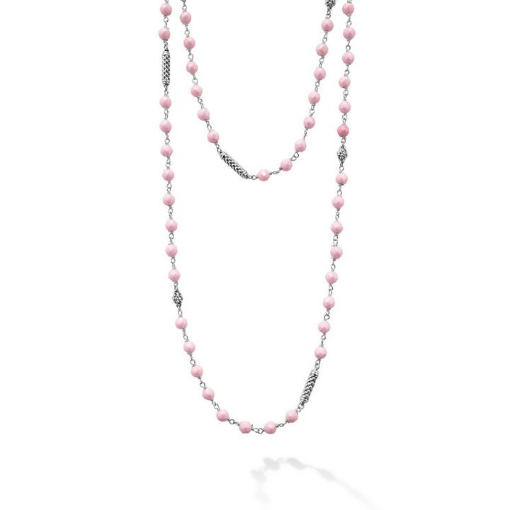 A close-up of a sterling silver and ceramic beaded necklace in the middle of a white background featuring Pink ceramic and silver Caviar beading.