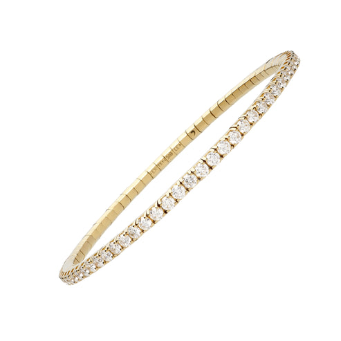 A 18K yellow gold diamond stretch bracelet angled in the middle of a white background