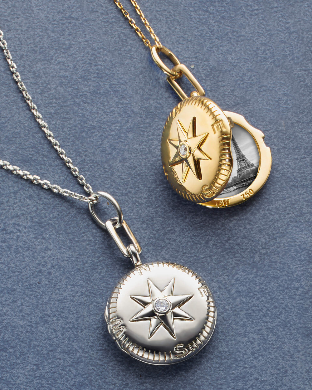 A display of two Gold Locket necklaces is accented with White Diamonds against a gray background. The locket holds two images. The locket on the right shows the front of the locket, highlighting the compass design, and the one on the left is opened, showing two pictures.