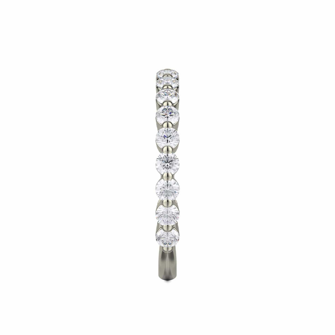 A side profile view of a white gold wedding band against a white background. The ring features a 3/4 eternity style with prong-set round diamonds.
