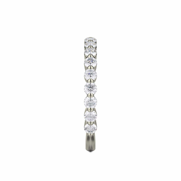 A side profile view of a white gold wedding band against a white background. The ring features a 3/4 eternity style with prong-set round diamonds.