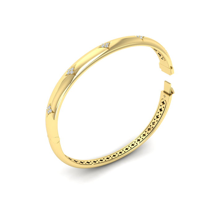 An angled view of a yellow-gold bracelet is set against a white background, showing the inside of the bracelet. The bracelet features a diamond-set star design across the yellow gold bangle with the clasp open.