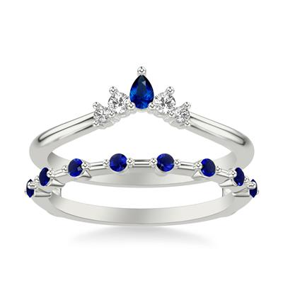 A white gold insert ring is set in a white background. The ring features a row of round-shaped sapphire diamond stations, with a pear-shaped marquise diamond in the middle and four prong-set round-shaped diamonds in the top row.