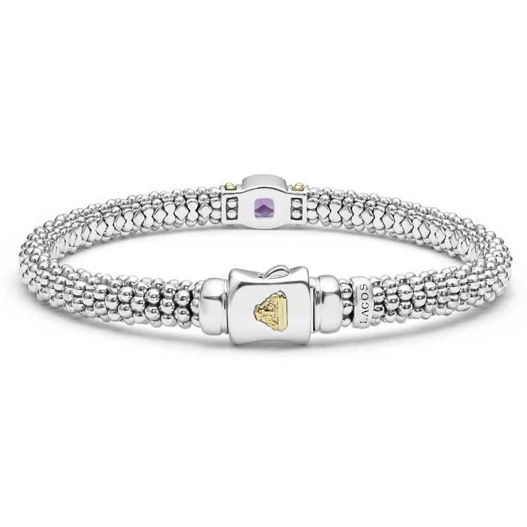 A sterling silver bracelet in the middle of a white background highlighting the clasp features an amethyst gemstone and sterling silver Caviar beading with 18K gold detailing.