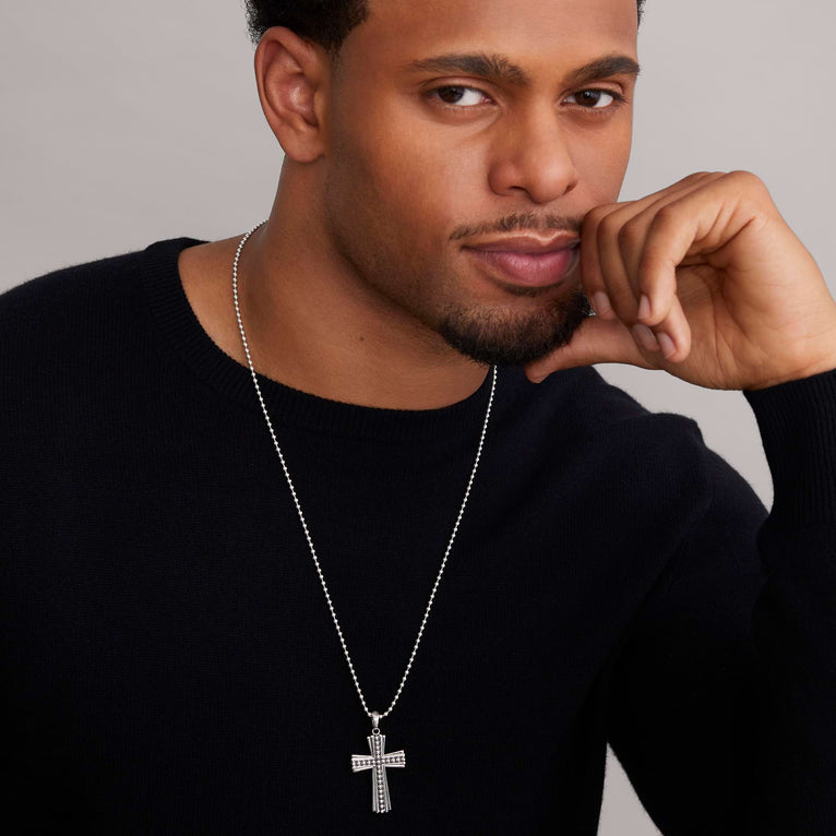 A man wearing a Cross Amulet featuring Signature Caviar beads accentuated by highly polished sterling silver with a chain necklace