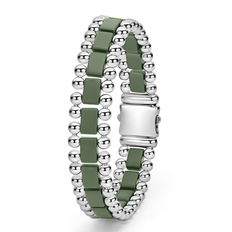 A stainless steel bracelet standing vertically in the middle of a white background featuring matte hunter-green ceramic and caviar beading.