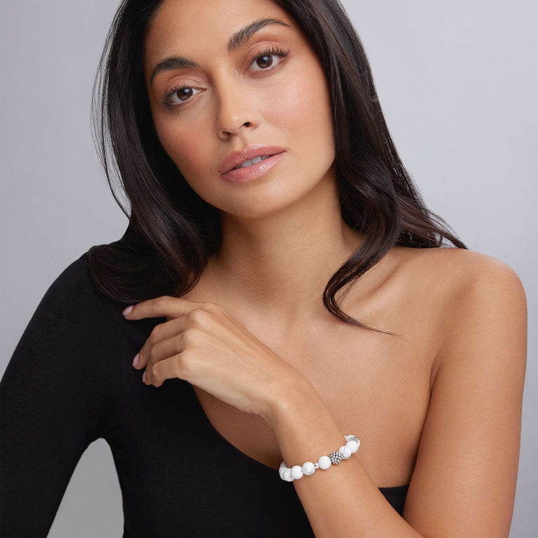 A woman wears a bracelet featuring Howlite gemstone and a silver Caviar bead station.