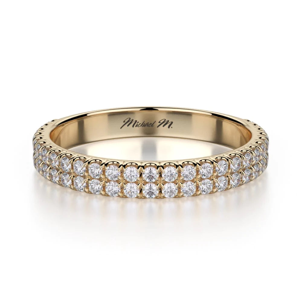 A yellow-gold ring lies flat against a white background. It features a two-row bezel set of round diamonds, and the "Michael M" inscription is visible inside it.