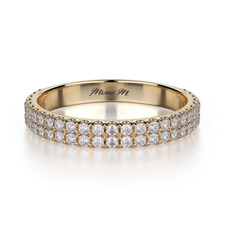 A yellow-gold ring lies flat against a white background. It features a two-row bezel set of round diamonds, and the "Michael M" inscription is visible inside it.