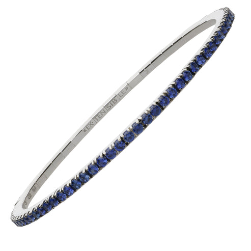 A diamond tennis bracelet is angled to the right against a white background. The bracelet features round-shaped sapphire diamonds set with prongs and Extensible engraved inside.