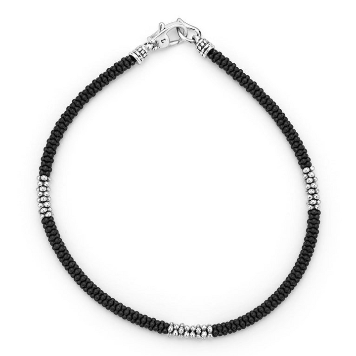 A bracelet in the middle of a white background featuring three sterling silver stations and Matte black ceramic caviar beading