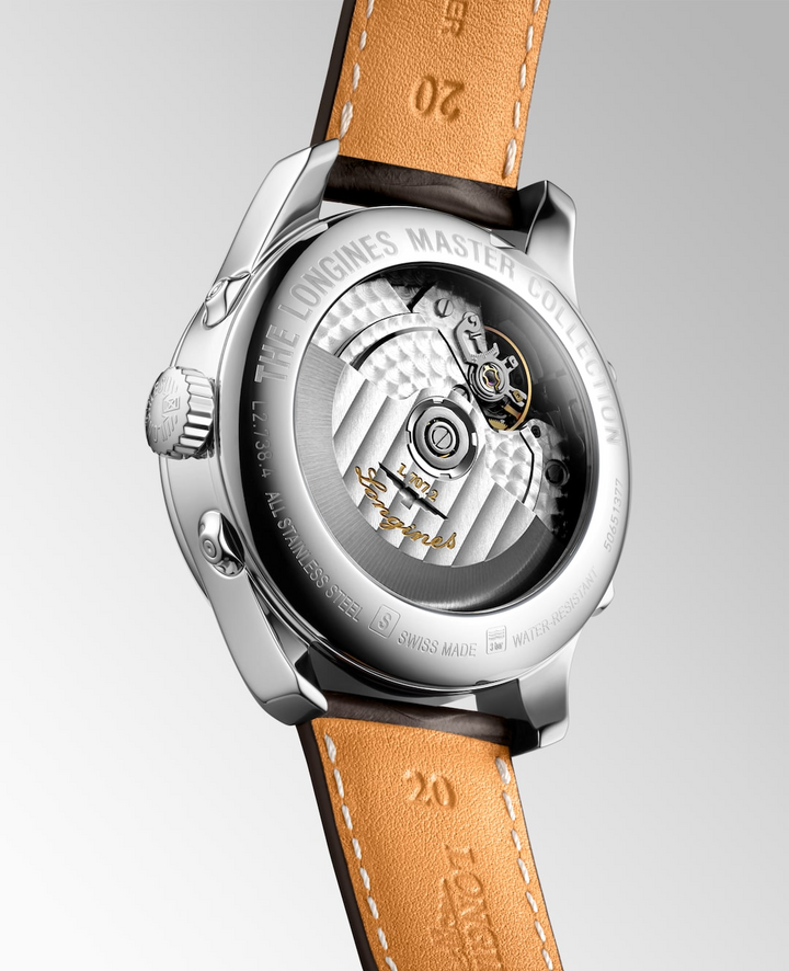 The back of a Longines watch is angled to the right, highlighting the case with an open heart design on the back and strap details. 