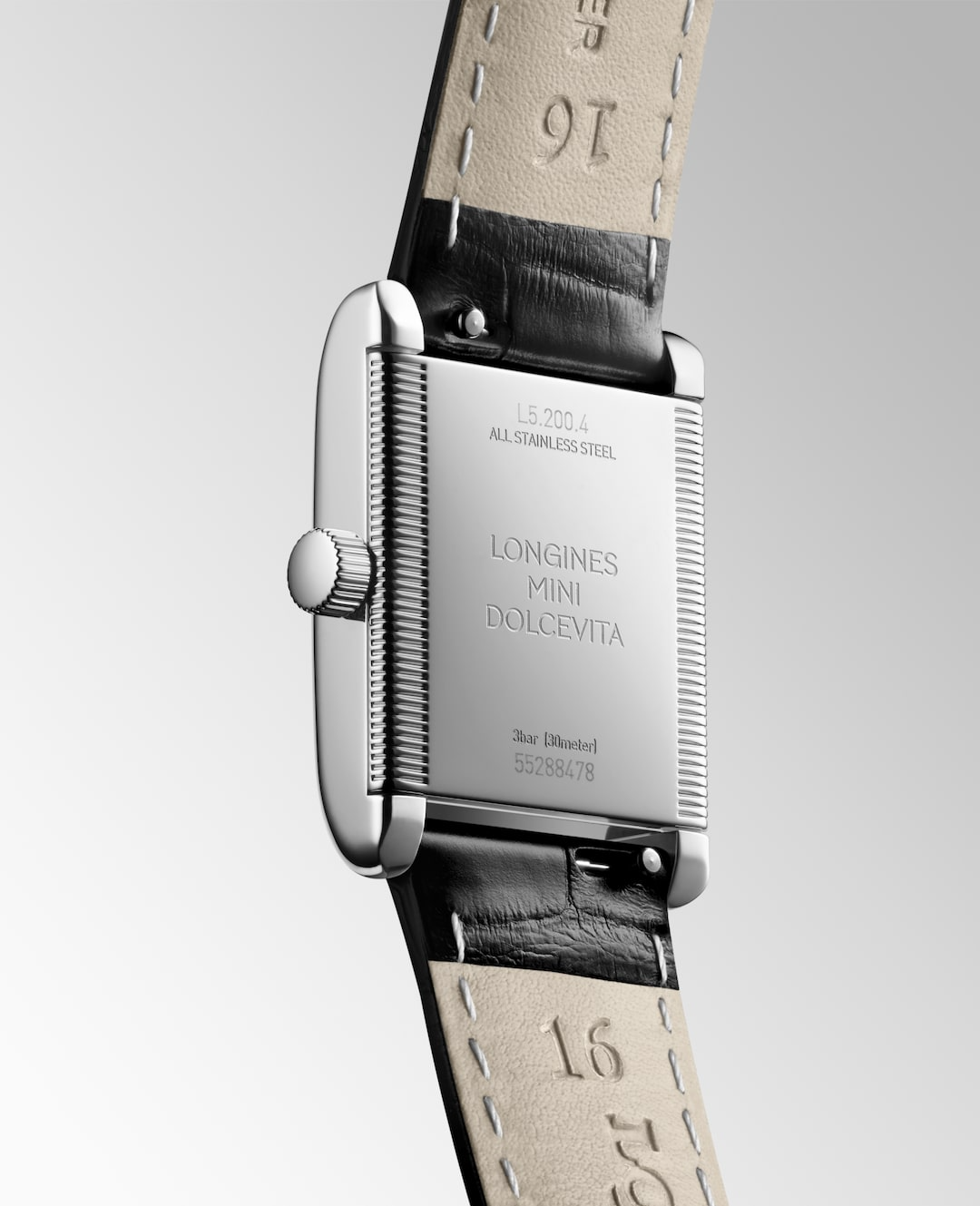 A Longines watch is displayed in the middle, angled to the right, showcasing the back of the dial on a white background. The back of the rectangular watch has Longines Mini DolceVita engraved on the middle of the dial.