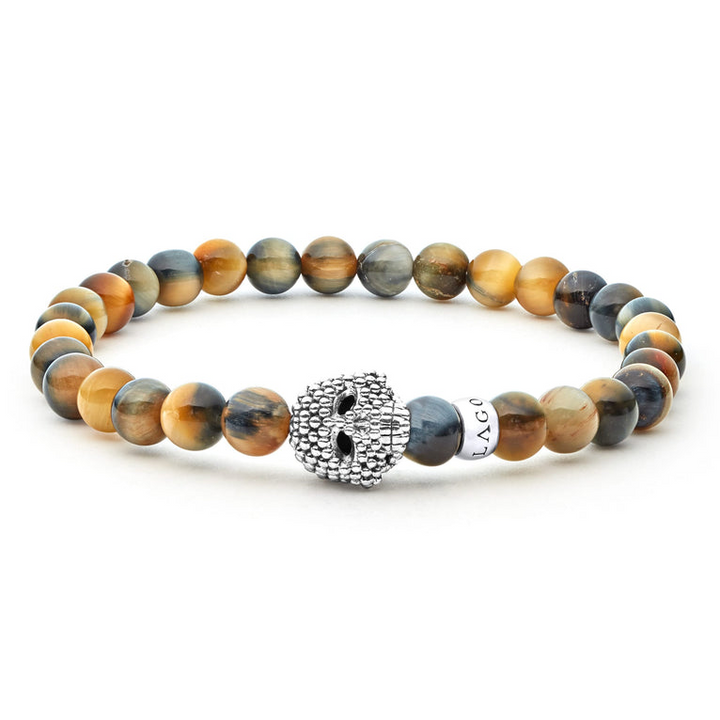 A sterling silver bracelet is displayed in the middle of a white background featuring a Tigereye gemstone beaded bracelet with a sterling silver Caviar skull.