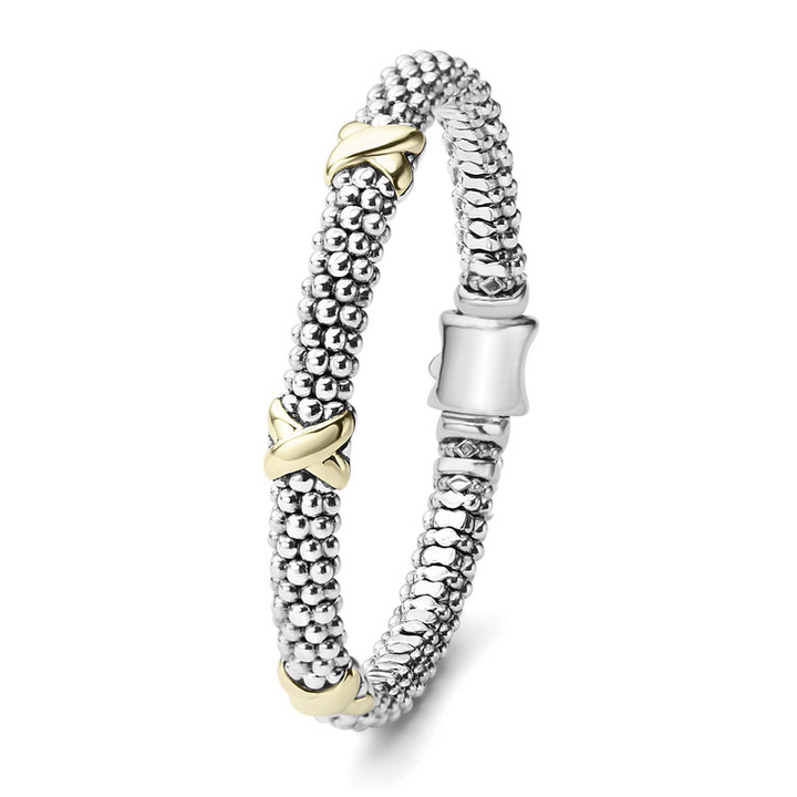 A sterling silver bracelet standing vertically in the middle of a white background featuring Caviar beading accented by three 18k gold x stations