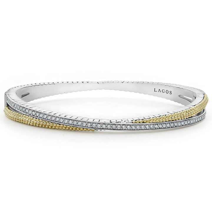 A Sterling Silver & 18k gold bangle bracelet resting in the middle of a white background. The bracelet has caviar beading with an X design.