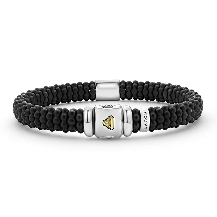 A back-view of a sterling silver beaded bracelet in the middle of a white background, featuring Matte black ceramic caviar beading and a gold single station