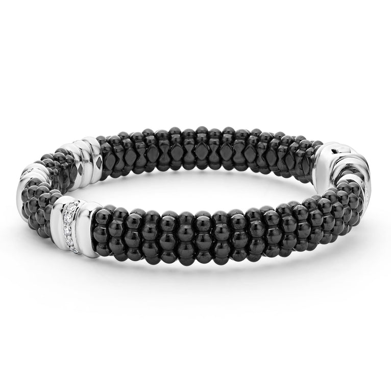 A side-view of a sterling silver bracelet in the middle of a white background featuring three diamond stations, black ceramic caviar beading, and sterling silver stations