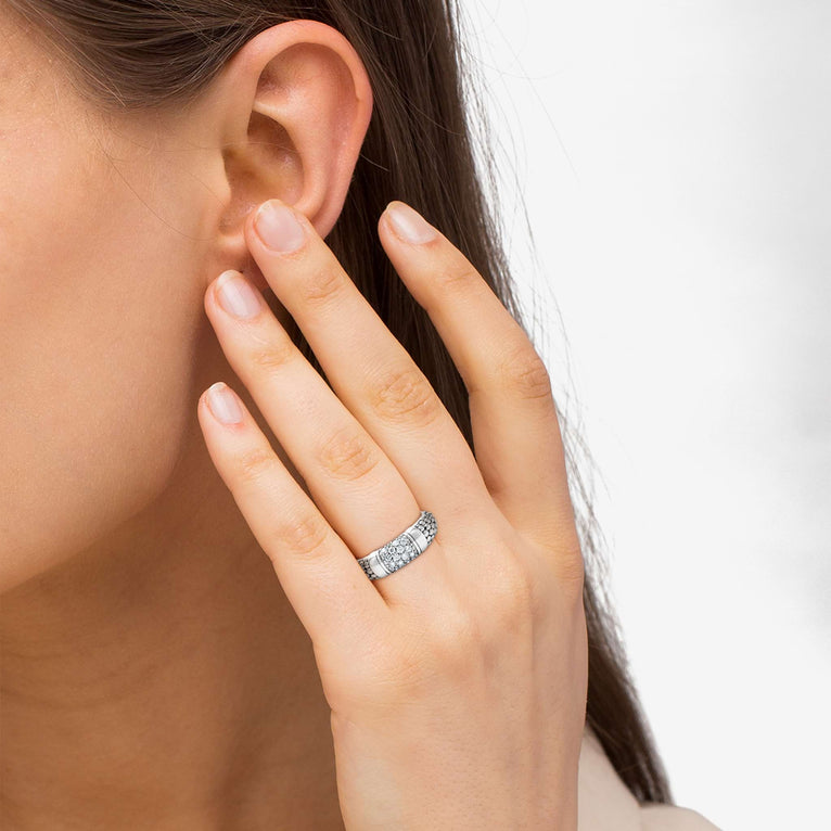 A woman wearing a sterling silver ring featuring Pavé diamonds and silver Caviar beading