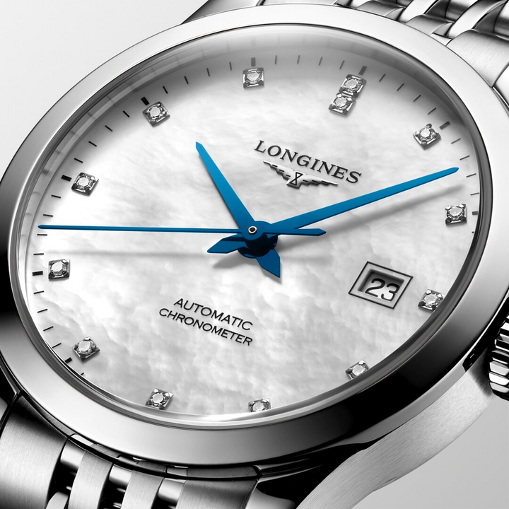 This is a close-up of a Longies watch angled to the right, showcasing the dial with a white background. The watch features a mother-of-pearl diamond-set dial, blue hands, black markers, a stainless steel bezel, and a stainless steel bracelet.