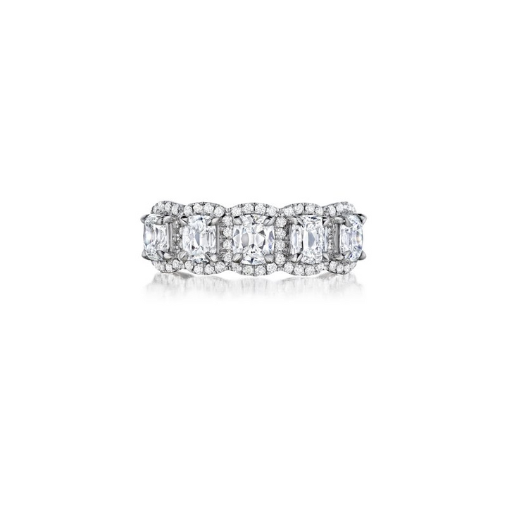 A front view of a white gold wedding band against a white background. The ring features five brilliant cushion-shaped diamonds surrounded by diamond-set halos with round-shaped diamonds.