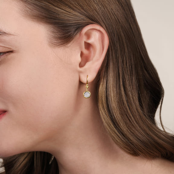 Model wearing a Gabriel & Co Bujukan diamond cluster earring, showing the two-tone gold design just below the earlobe.