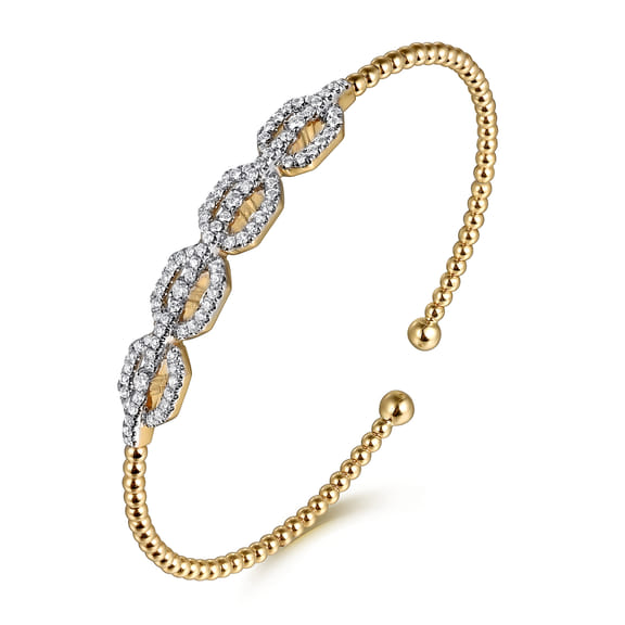 Angled view of the Gabriel & Co Bujukan bangle showing its diamond-set links, beaded yellow gold band and open ends.