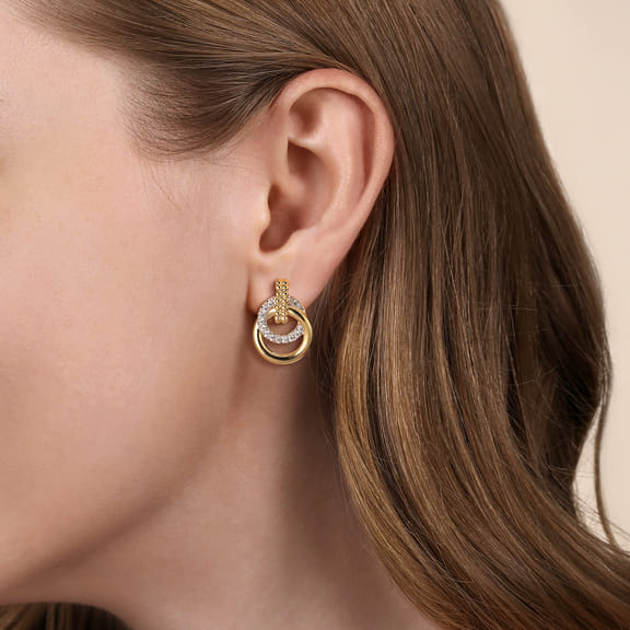 Model wearing a Gabriel & Co Bujukan stud earring, showing the interlocking yellow gold and diamond circles on the ear.