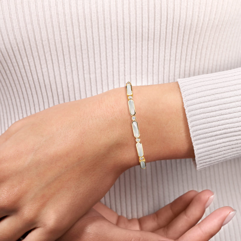 Model wearing the Gabriel & Co Bujukan bangle, showing the mother-of-pearl stations and diamond accents across the wrist.