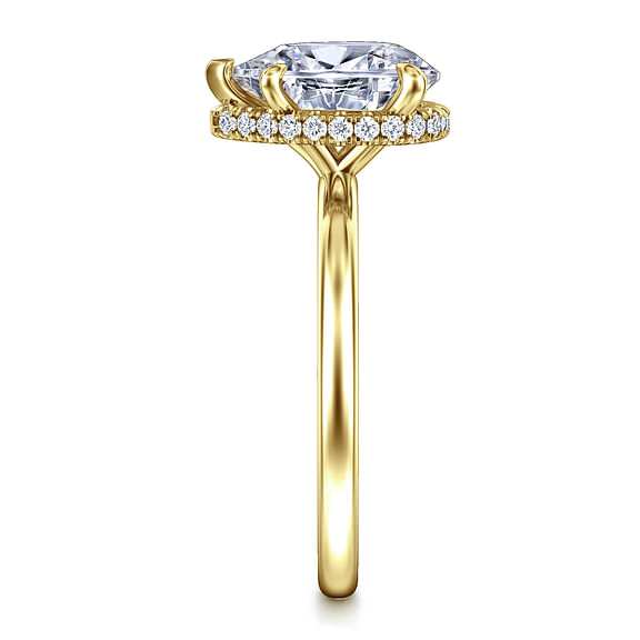 End view of a yellow gold pear engagement ring showing the diamond halo beneath the center stone and open basket supports.