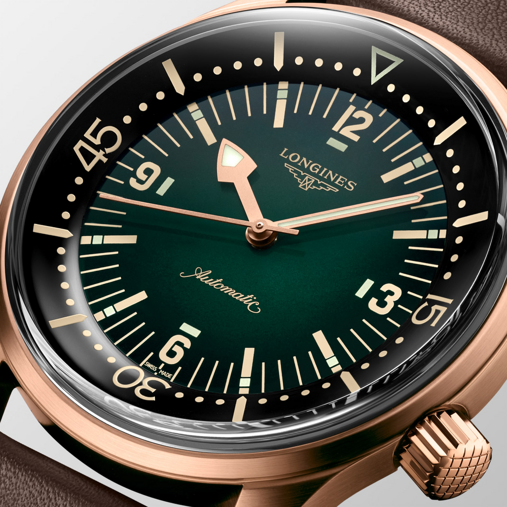 Close up of a LONGINES Legend Diver Bronze watch with a dark green dial and a brown leather strap.