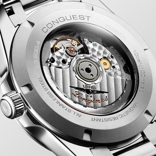 Close-up of the LONGINES Conquest transparent caseback showing the automatic movement and engraved steel case.