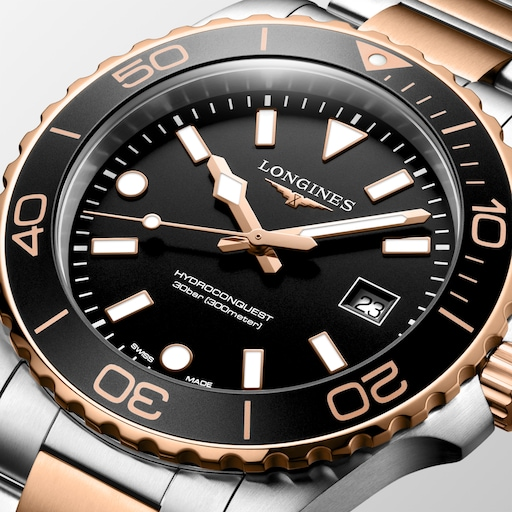 Close-up of the LONGINES HydroConquest L3.769.3.58.7 black dial, luminous markers, date window and two-tone bezel.