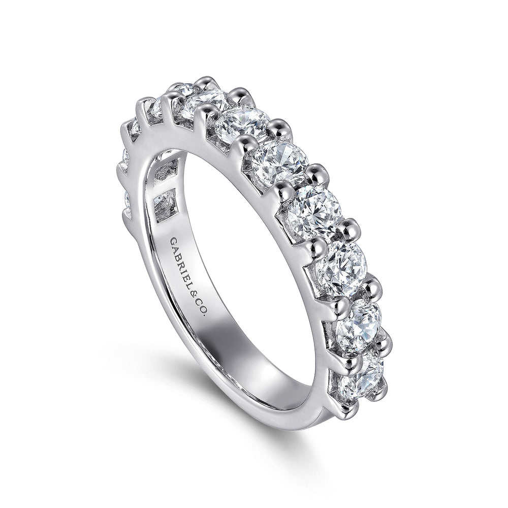 An angled view of a white gold wedding band against a white background. The ring features a half eternity style with eleven round-shaped diamonds held securely in a shared prong setting.