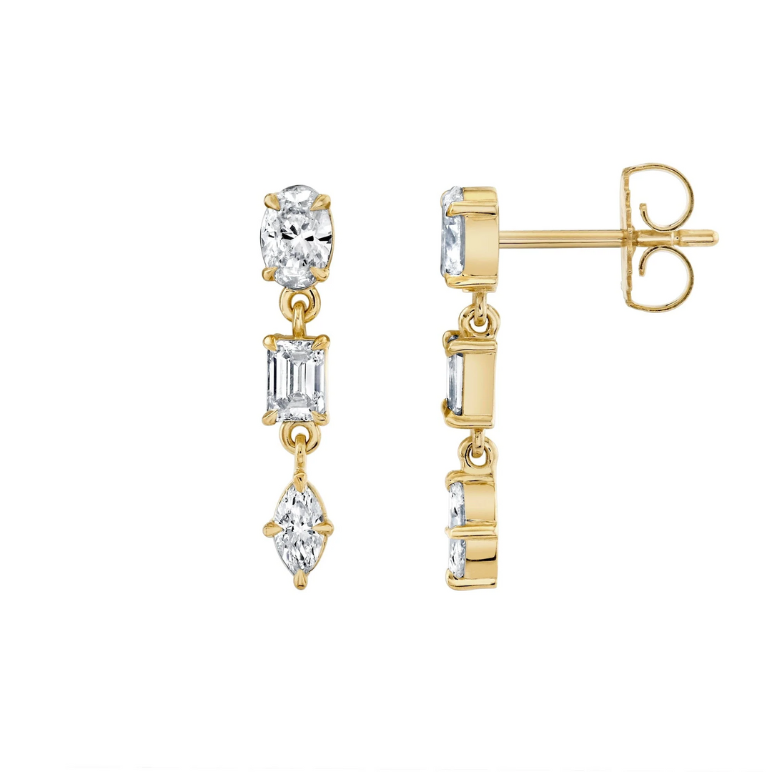 A pair of yellow gold earrings against a white background; the right earring is positioned on its side, and the left earring is facing forward. The earrings feature a drop design with oval, emerald, and marquise-cut diamonds.