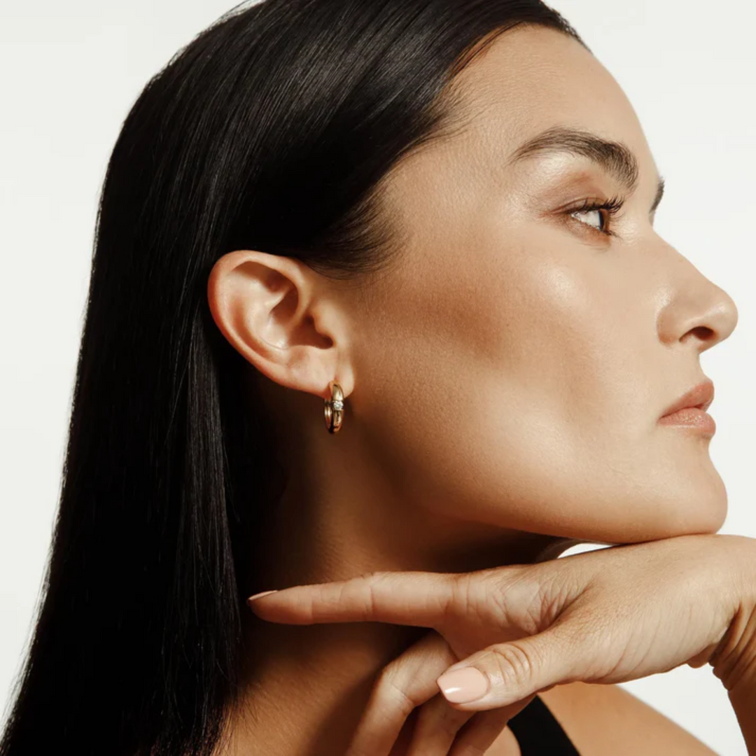 Model wearing a MICHAEL M Orb Split gold hoop earring with a single diamond accent