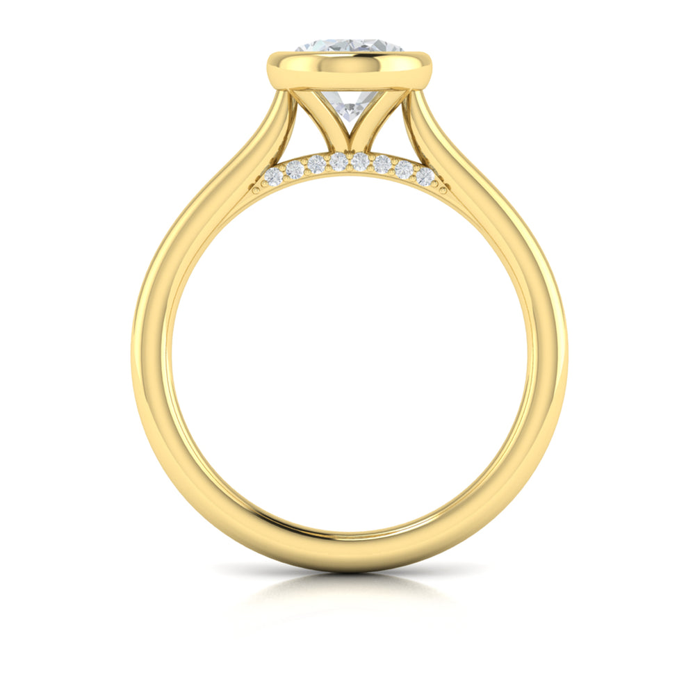 A top view of a yellow gold engagement ring is set against a white background. The engagement ring features a bezel-set oval diamond center stone with a cathedral setting, and has subtle pavé detailing around the yellow gold band.