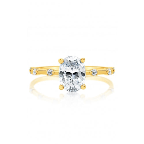 Front view of a yellow gold oval solitaire engagement ring with four prongs and spaced round diamond accents along a slim band.