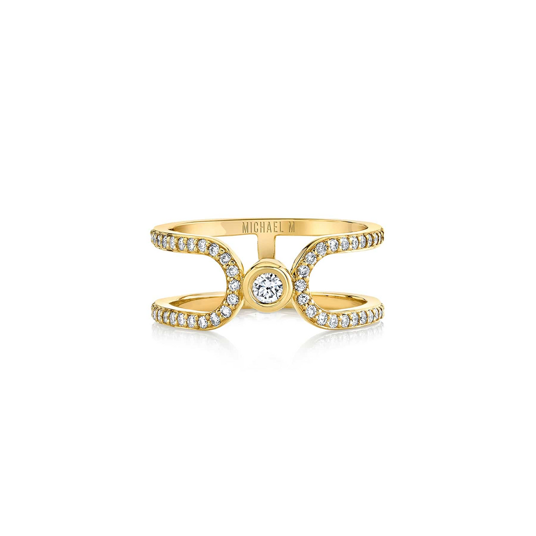 A front view of a yellow gold wedding band against a white background. The ring features an elongated link that wraps around and squeezes a diamond-set bezel.