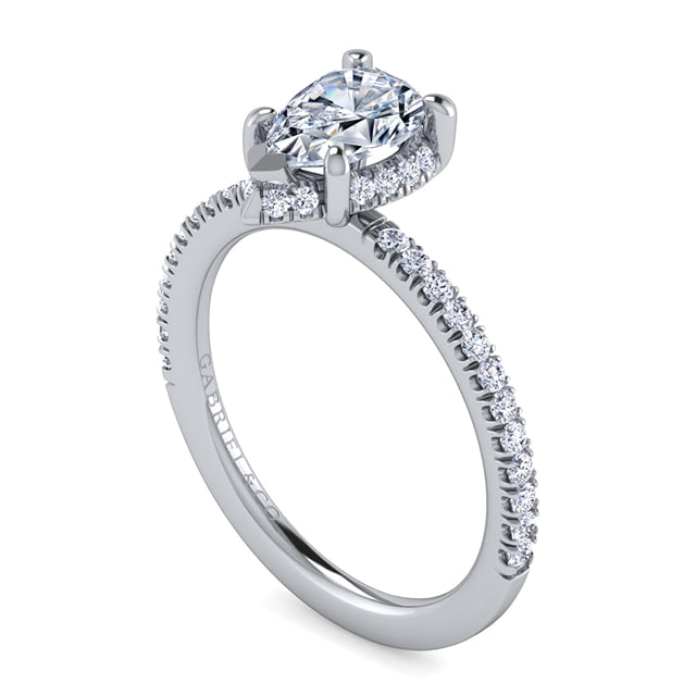 Angled view of a Gabriel & Co. pear diamond engagement ring showing the hidden diamond halo and pavé white gold band.