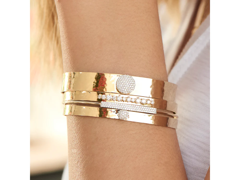 Model wearing the Phillips House Infinity Love Always Bracelet with other gold bracelets.