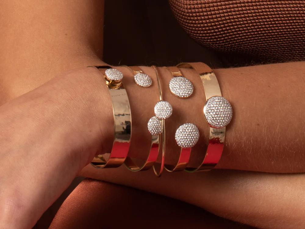 Model wearing the Phillips House Infinity Wire Love Always Bracelet alongside other bracelets, showing its diamond disc on the wrist.