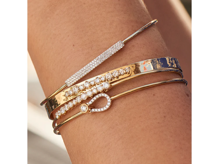 Model wearing the Phillips House Wire Affair Strap Bracelet alongside other yellow gold and diamond bracelets.