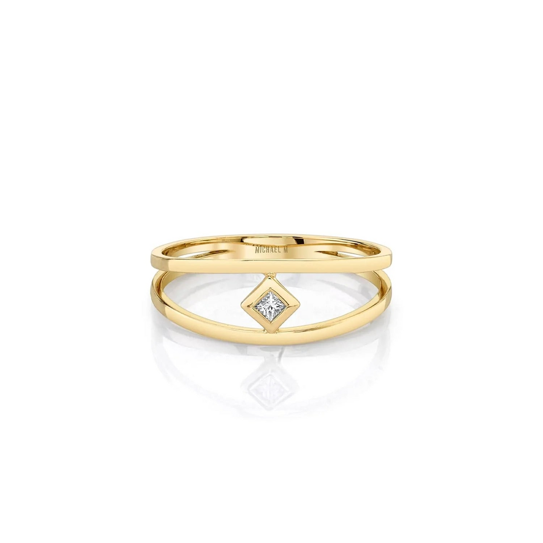 A yellow gold ring in the middle of a white background. The ring features a diamond-set center piece and two yellow-gold rows with Michael M. engraved inside the ring.