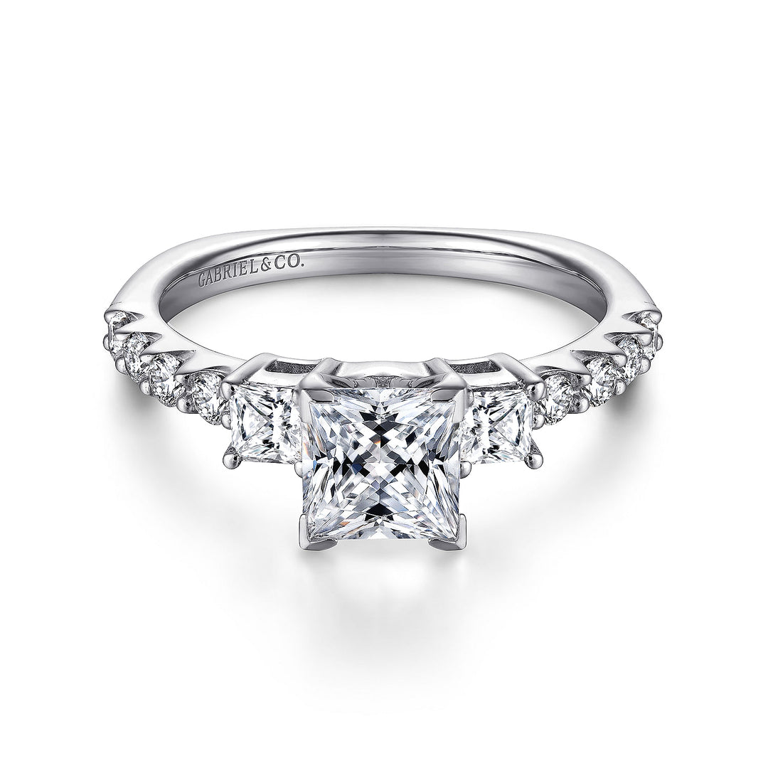 Front view of a princess cut three stone engagement ring with square side diamonds and round diamond accents along the band.