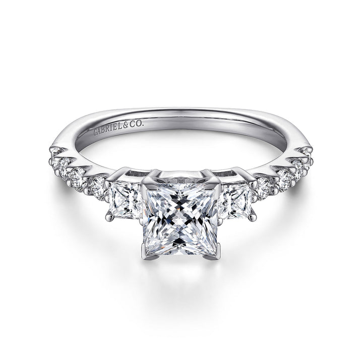 Front view of a princess cut three stone engagement ring with square side diamonds and round diamond accents along the band.