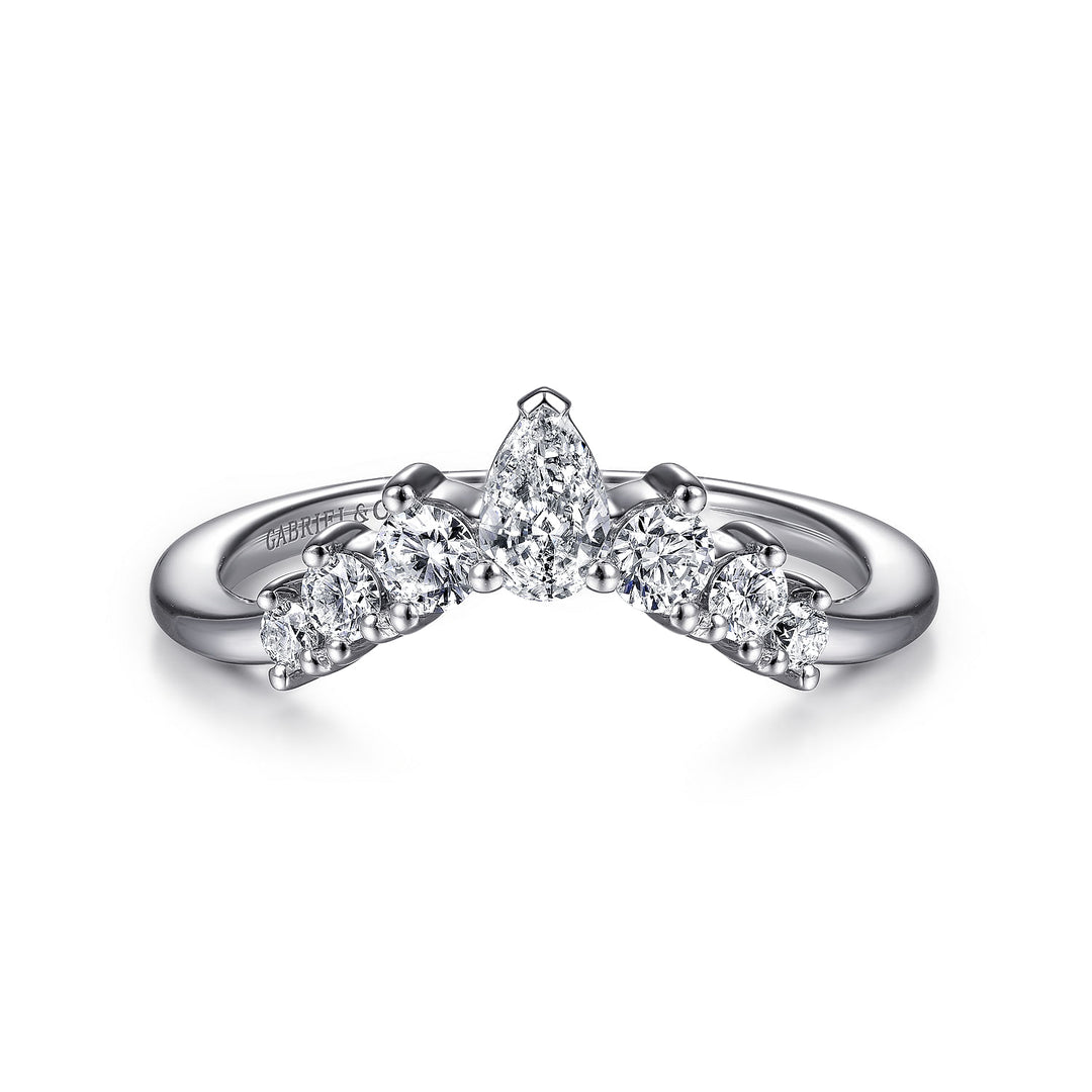 A white gold ring laid flat in the middle of a white background. The ring features a tiara design with a pear-shaped center stone and six round diamonds, and Gabriel & Co engraved inside the ring on the left side.